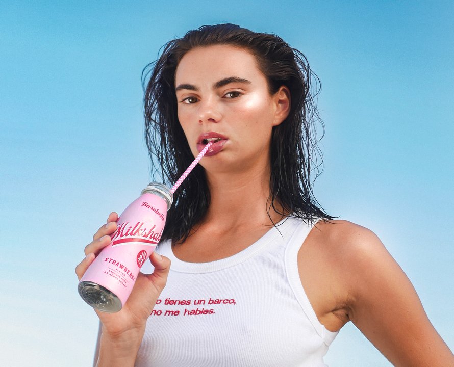 Anne Charlotte, close portrait — looking at the camera with a milkshake bottle and a paper straw