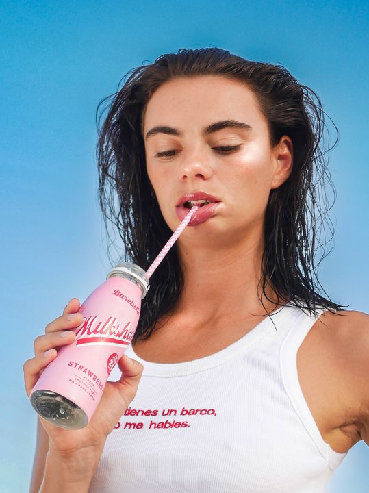 Anne Charlotte, close portrait — eyes down, sipping a milkshake through a straw