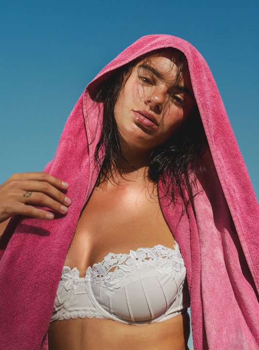 Anne Charlotte, portrait — pink towel over her head against a deep blue sky
