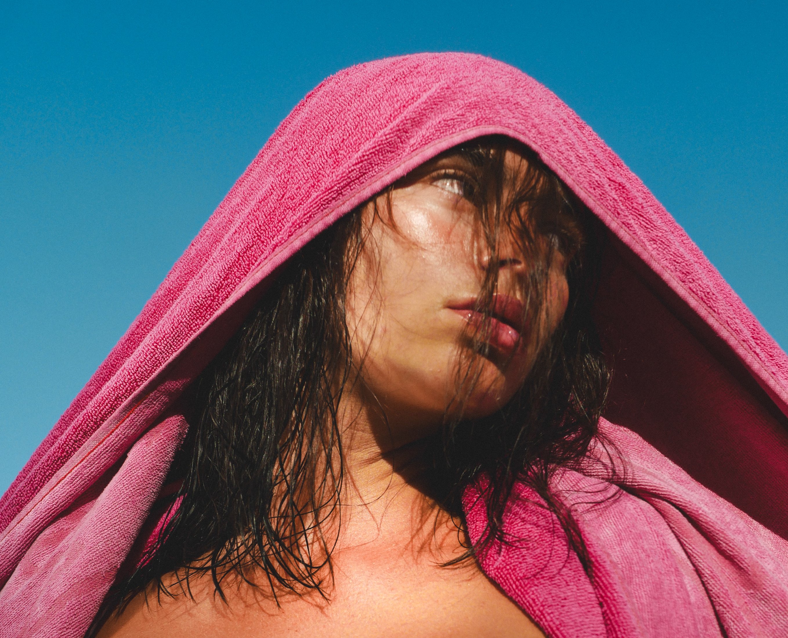 Anne Charlotte, close portrait — pink towel hood and wet hair, blue sky